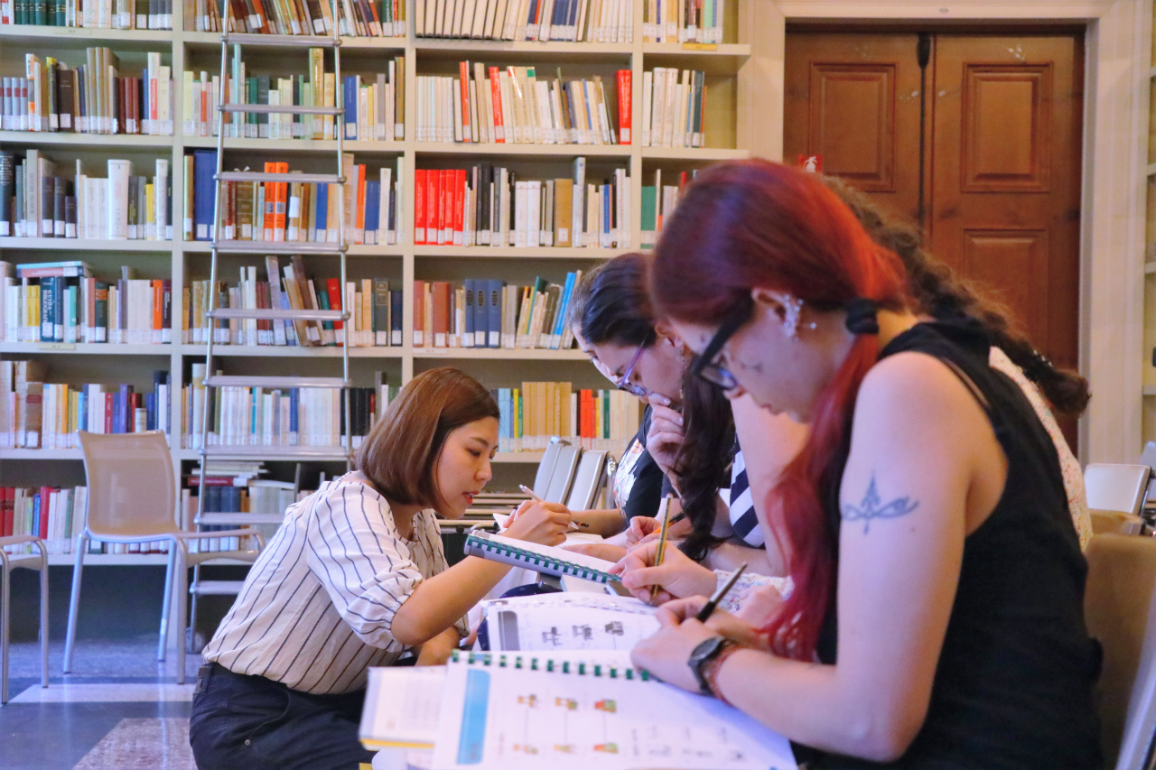 A teacher helps pupils during a Korean class at the King Sejong Institute in Rome. (King Sejong Institute Foundation)