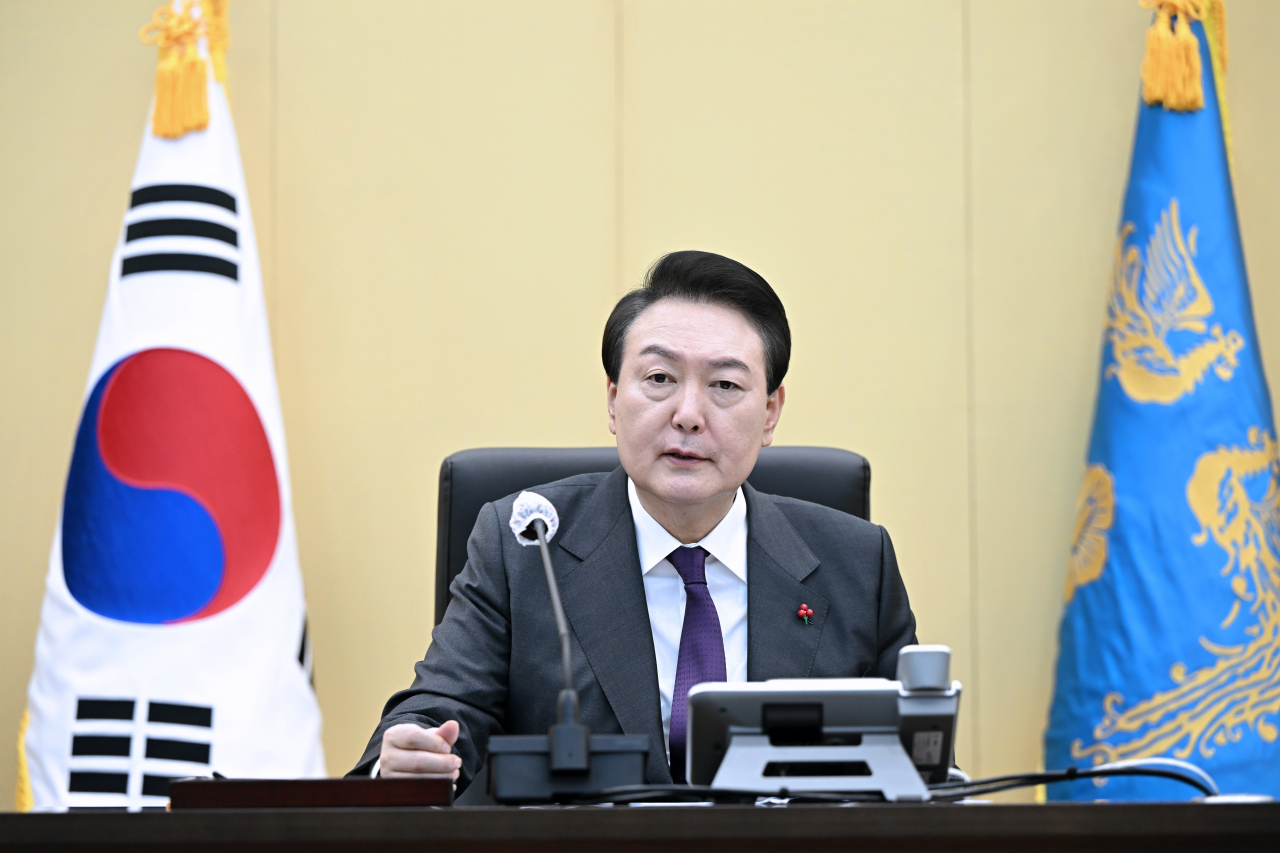 President Yoon Suk-yeol sits behind a desk on Sunday in this photo (Presidential office)