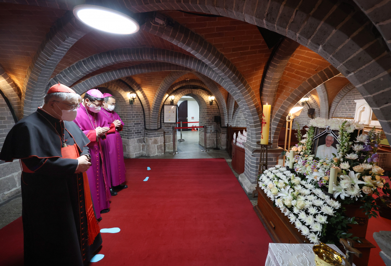 Cardinal Andrew Yeom Soo-jung (left) and Archbishop Peter Chung Soon-taick of the Seoul archdiocese (second from left) pay tribute to former Pope Benedict XVI at a memorial altar set up in Myeongdong Cathedral in central Seoul on Sunday. (Yonhap)