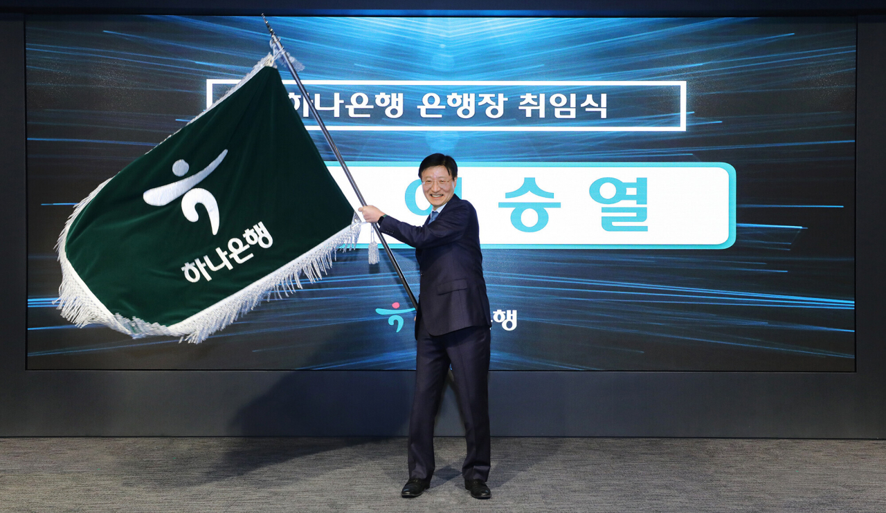 New Hana Bank CEO Lee Seung-lyul waves the bank's flag during an inauguration ceremony held at its headquarters in Seoul on Monday. (Hana Financial Group)