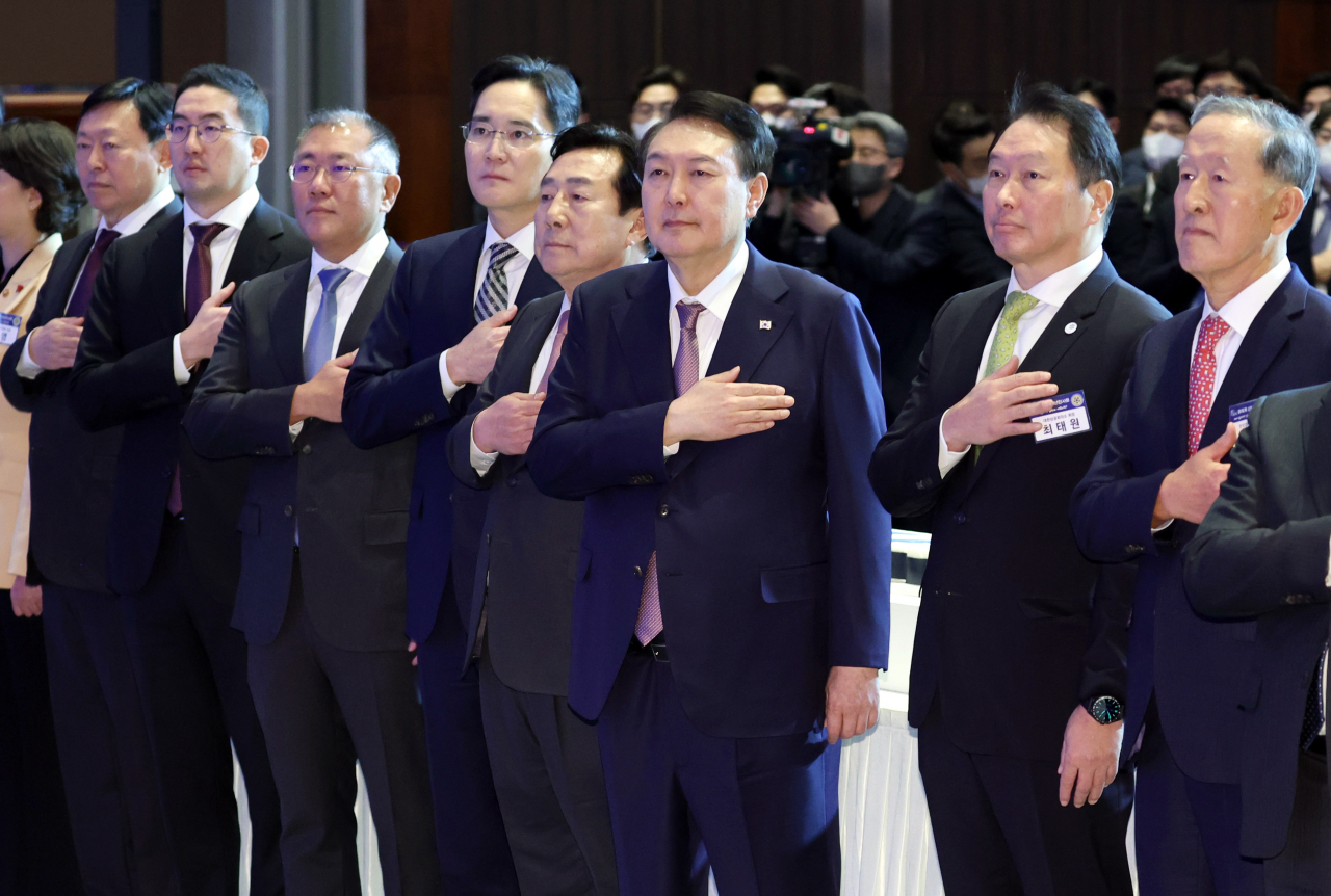 President Yoon Suk-yeol (third from right) salutes the national flag with business leaders during a New Year's gathering of the business community, hosted by the KCCI and the KBIZ, held at Coex in southern Seoul, Monday. From left are Lotte Group Chairman Shin Dong-bin, LG Group Chairman Koo Kwang-mo, Hyundai Motor Group Executive Chair Chung Euisun, Samsung Electronics Chairman Lee Jae-yong, Korea Federation of SMEs Chairman Kim Ki-moon, President Yoon, Korea Chamber of Commerce and Industry Chairman and SK Group Chairman Chey Tae-won and Federation of Korean Industries Chairman and GS Group Group Chairman Huh Chang-soo. (Yonhap)