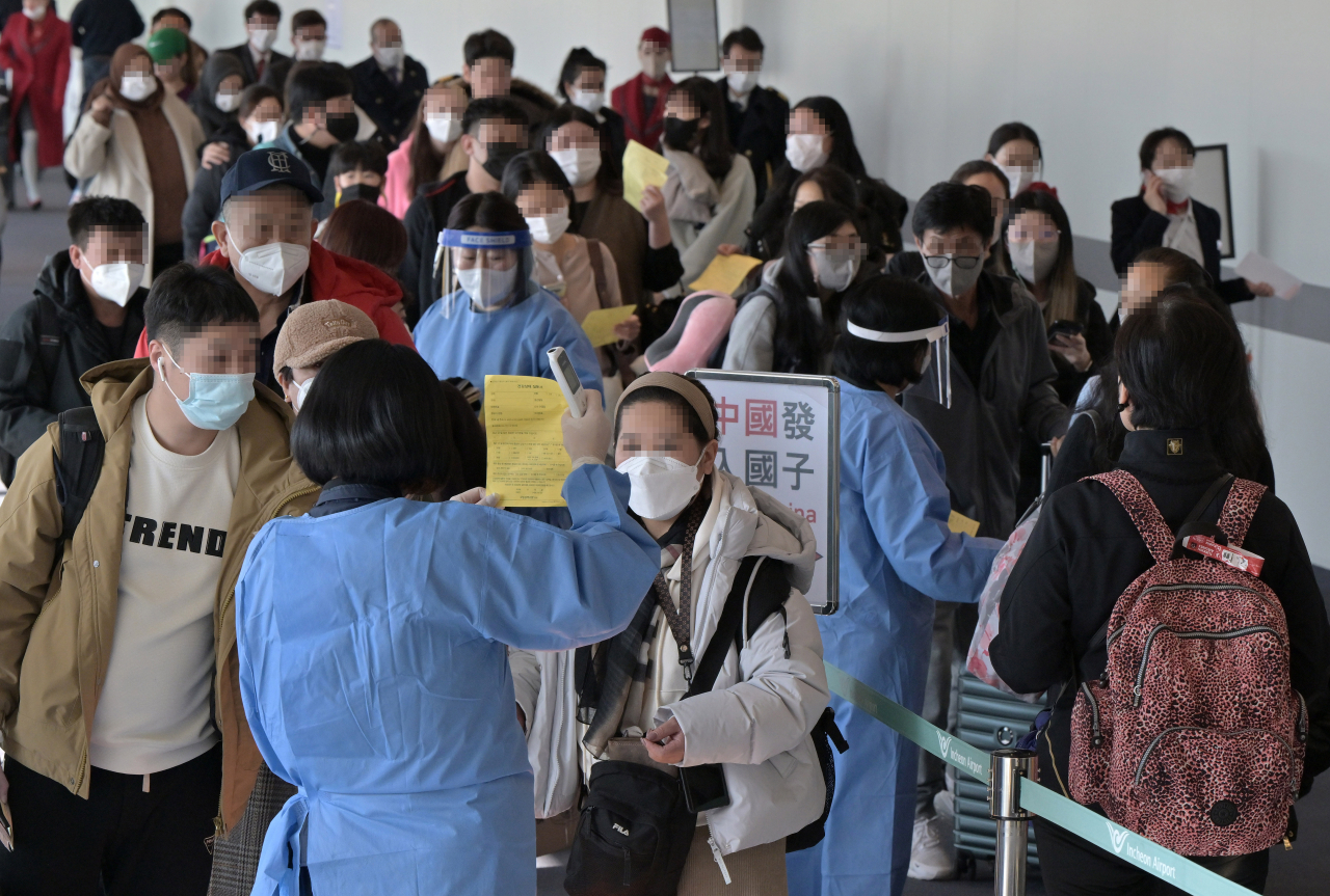 Quarantine officials introduce procedures for COVID-19 tests to entrants from China upon their arrival at Incheon International Airport, west of Seoul, on Monday, when South Korea began to require a PCR test for all travelers from China as the virus rapidly spreads in the neighboring country. (Yonhap)
