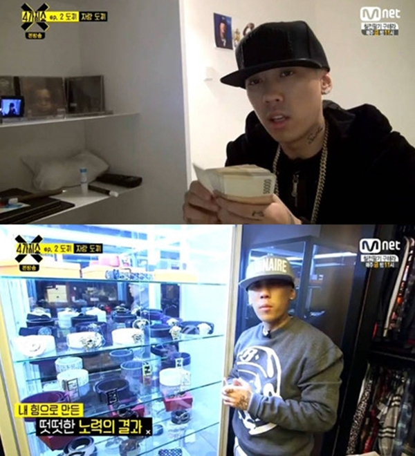 Dok2 shows off stacks of money and numerous luxury items in his home during a 2015 Mnet appearance. (Mnet)