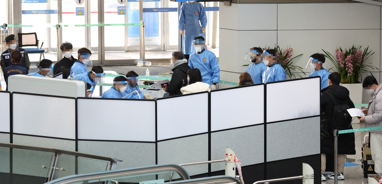 Entrants from China wait after taking a COVID-19 test upon arrival at Incheon International Airport, west of Seoul, on Tuesday, as South Korea began to require a polymerase chain reaction test for all travelers from China the previous day as the virus quickly spreads in the neighboring country. (Yonhap)