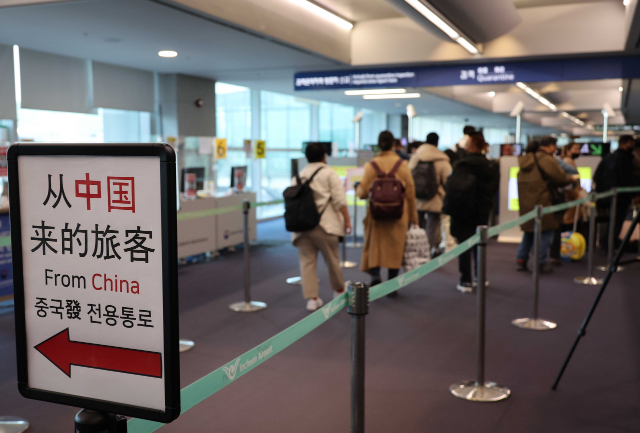 Inbound passengers from China, Hong Kong and Macao wait to take COVID-19 tests at Incheon International Airport, west of Seoul, on Friday. (Yonhap)