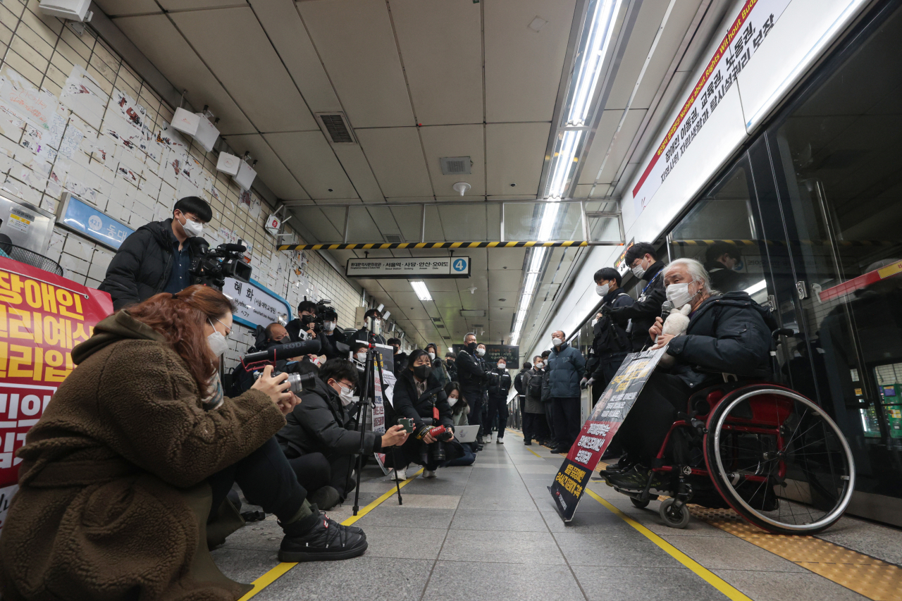 Disabled activists from Solidarity Against Disability Discrimination hold a propaganda campaign at Hyehwa Station on Jan. 4. (Yonhap)