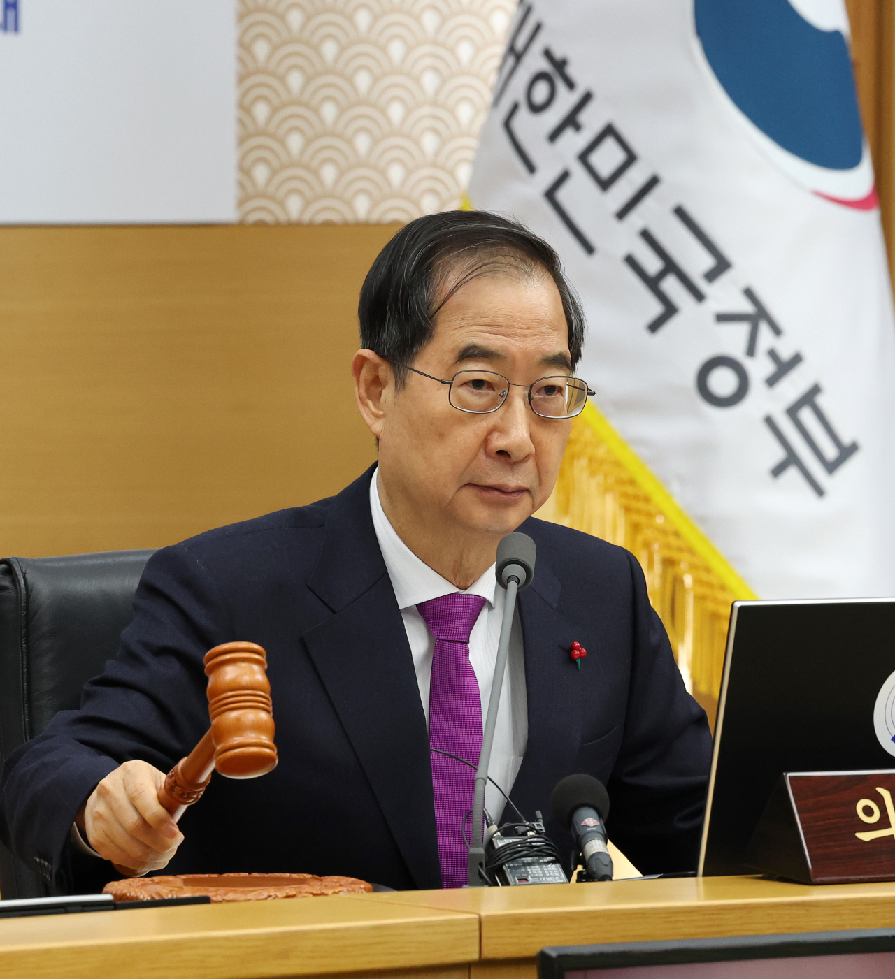 Prime Minister Han Duck-soo bangs the gavel to open a Cabinet meeting at the government complex in Sejong, central South Korea, on Tuesday, which is connected via video link with the government complex in Seoul.