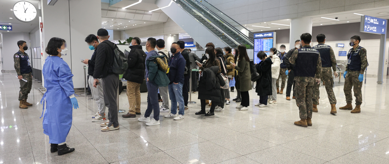 Passengers arriving from China wait to get tested for the coronavirus at Incheon International Airport, west of Seoul, on Monday. (Yonhap)