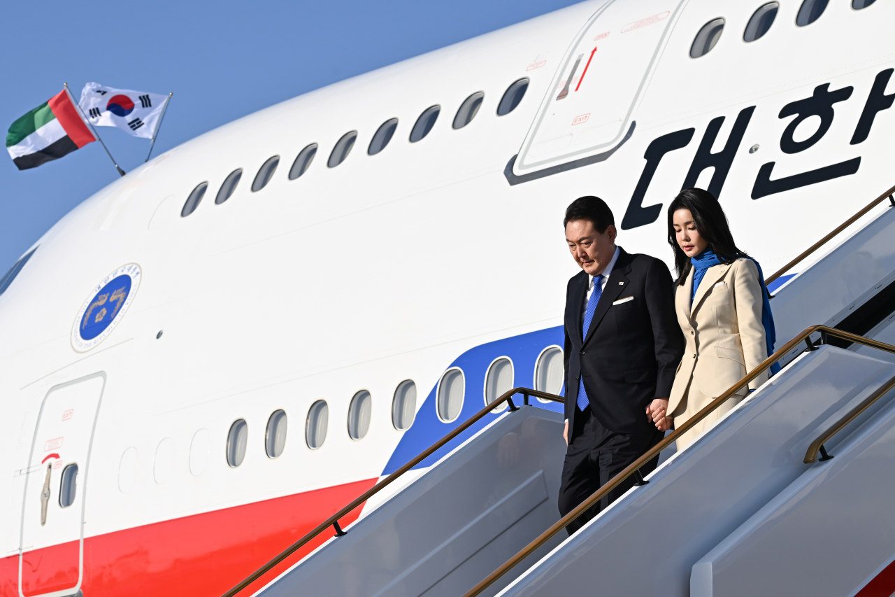 President Yoon Suk Yeol and first lady Kim Keon Hee disembark the presidential jet after arriving at Abu Dhabi International Airport in Abu Dhabi on Saturday. (Yonhap)