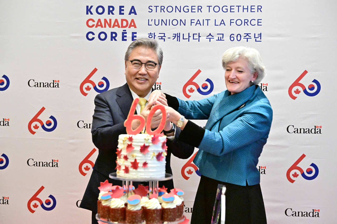 South Korean Foreign Minister Park Jin (left) and Tamara Mawhinney, Charge d' affaires at Canadian Embassy attend the cake-cutting ceremony at an event to commemorate 60th anniversary Canada-Korea relations in Jung-gu, Seoul, Thursday. (Ministry of Foreign Affairs)