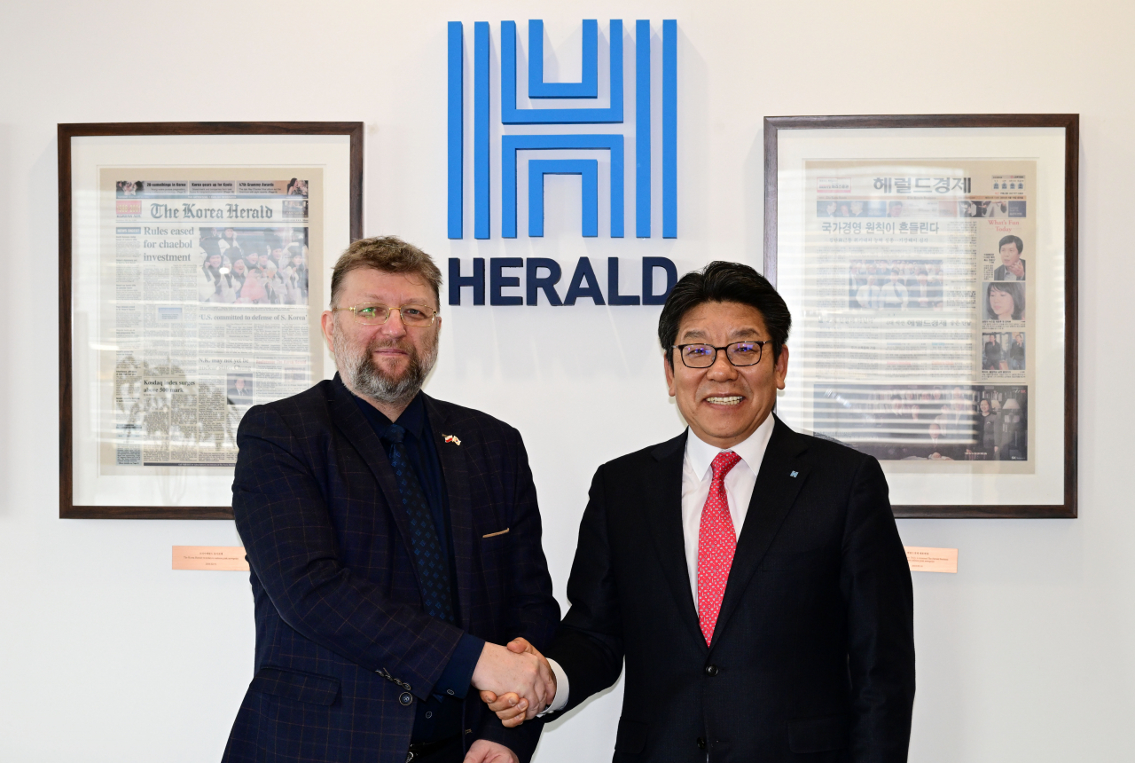 Piotr Ostaszewski Polish ambassador to South Korea, shakes hands with The Korea Herald CEO Choi Jin-young during a courtesy visit to the Herald Corp. headquarters in central Seoul on Thursday. (Park Hae-mook/The Korea Herald)