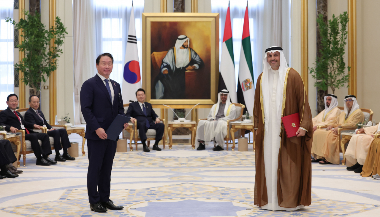 SK Group Chairman Chey Tae-won (left) poses for photos with Mubadala Investment Company's CEO Khaldoon Khalifa Al Mubarak after signing a memorandum of understanding on reducing carbon emissions at the United Arab Emirates presidential palace in Abu Dhabi on Sunday. (Yonhap)