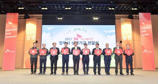 SK Innovation Vice Chairman Kim Jun (fifth from left), company officials and representatives from partner firms pose during the delivery ceremony for the 1 Percent Happiness Sharing Fund at the company’s Ulsan complex on Tuesday. (SK Innovation)