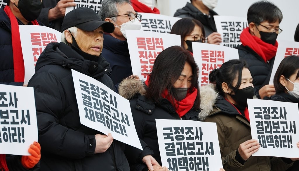 Parents of victims of the crowd disaster in Itaewon in October last year call on lawmakers to adopt the report on findings from the parliamentary probe outside the National Assembly building on Tuesday. (Yonhap)