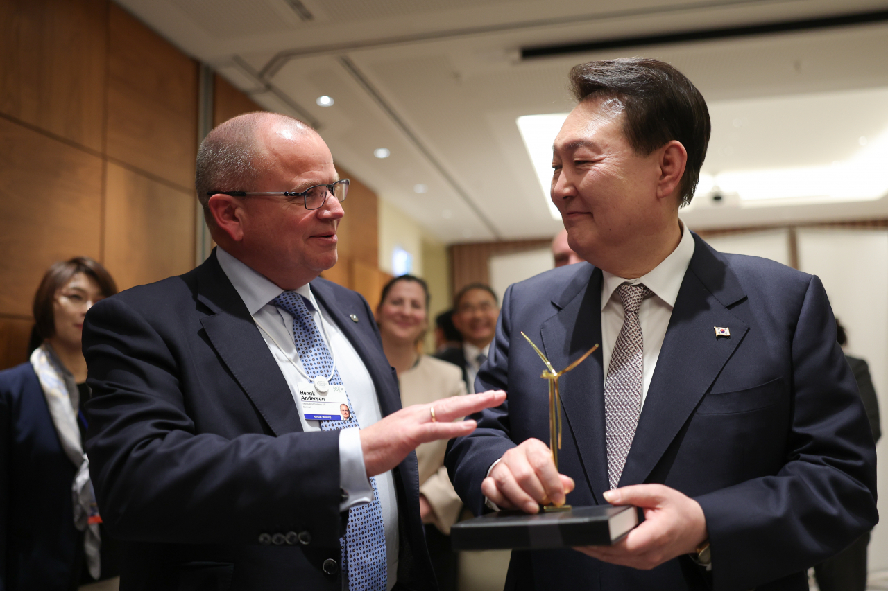 Vestas CEO Henrik Andersen (left) and President Yoon Suk Yeol hold a conversation at a hotel in Davos, Switzerland, on Wednesday. (Yonhap)
