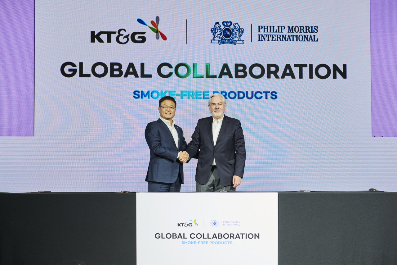 KT&G CEO Baek Bok-in (left) and PMI CEO Jacek Olczak shake hands after a signing ceremony held in Seoul, Monday. (KT&G)