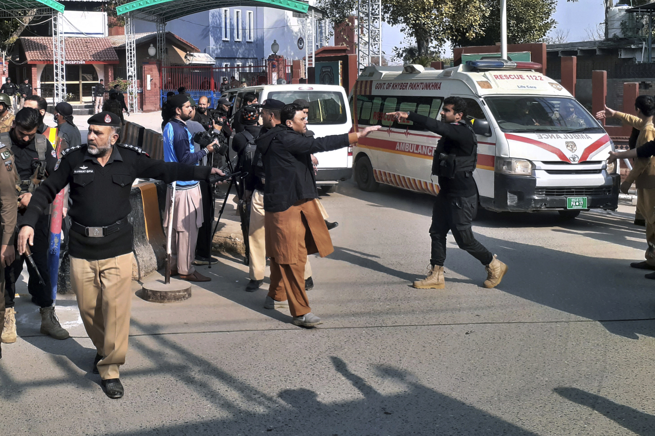 Police officers clear the way for ambulances leaving after carrying wounding people from bomb explosion site, at the main entry gate of police offices, in Peshawar, Pakistan, Monday, Jan. 30, 2023. A powerful bomb went off Monday near a mosque and police offices in the northwestern Pakistani city of Peshawar, killing at least a few people and wounding some 70 worshippers, police and government officials said. (AP)