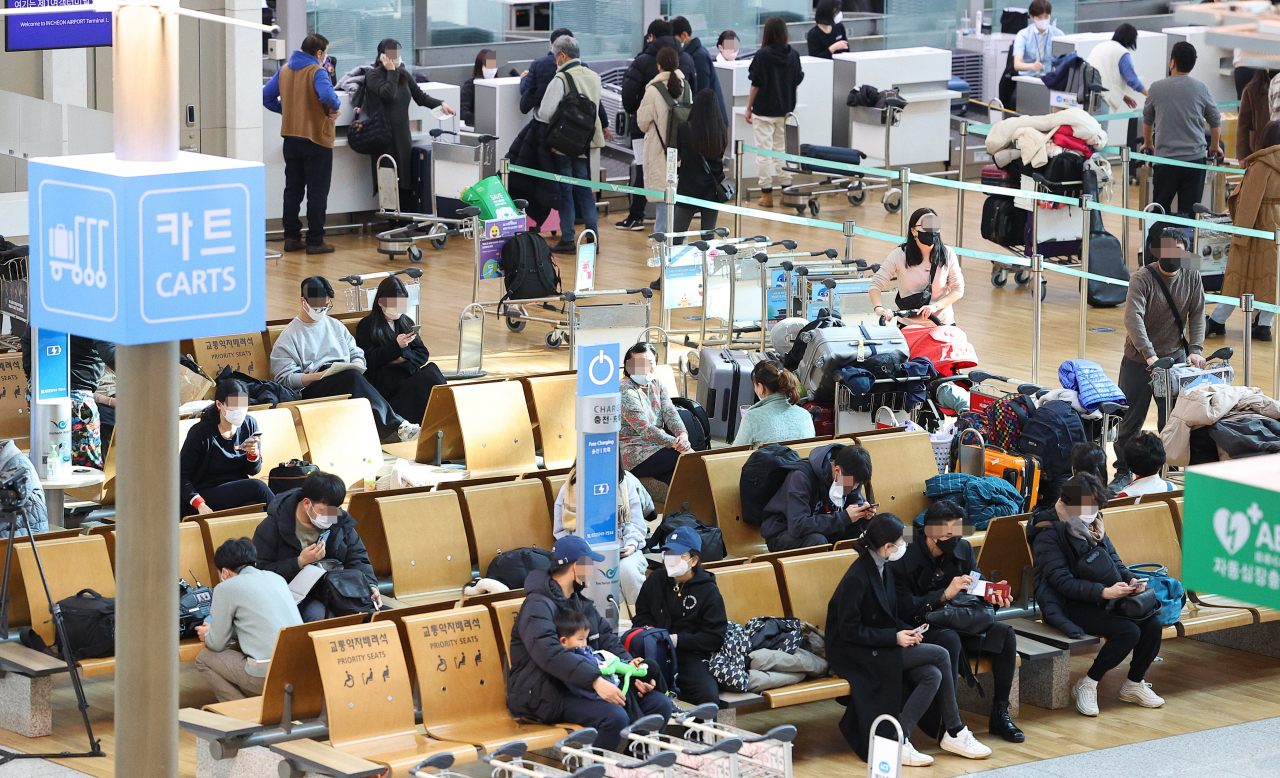 Most passengers continue to wear masks at Incheon International Airport, west of Seoul, on Monday, despite the lifting of the country's indoor mask mandate on the day. (Yonhap)