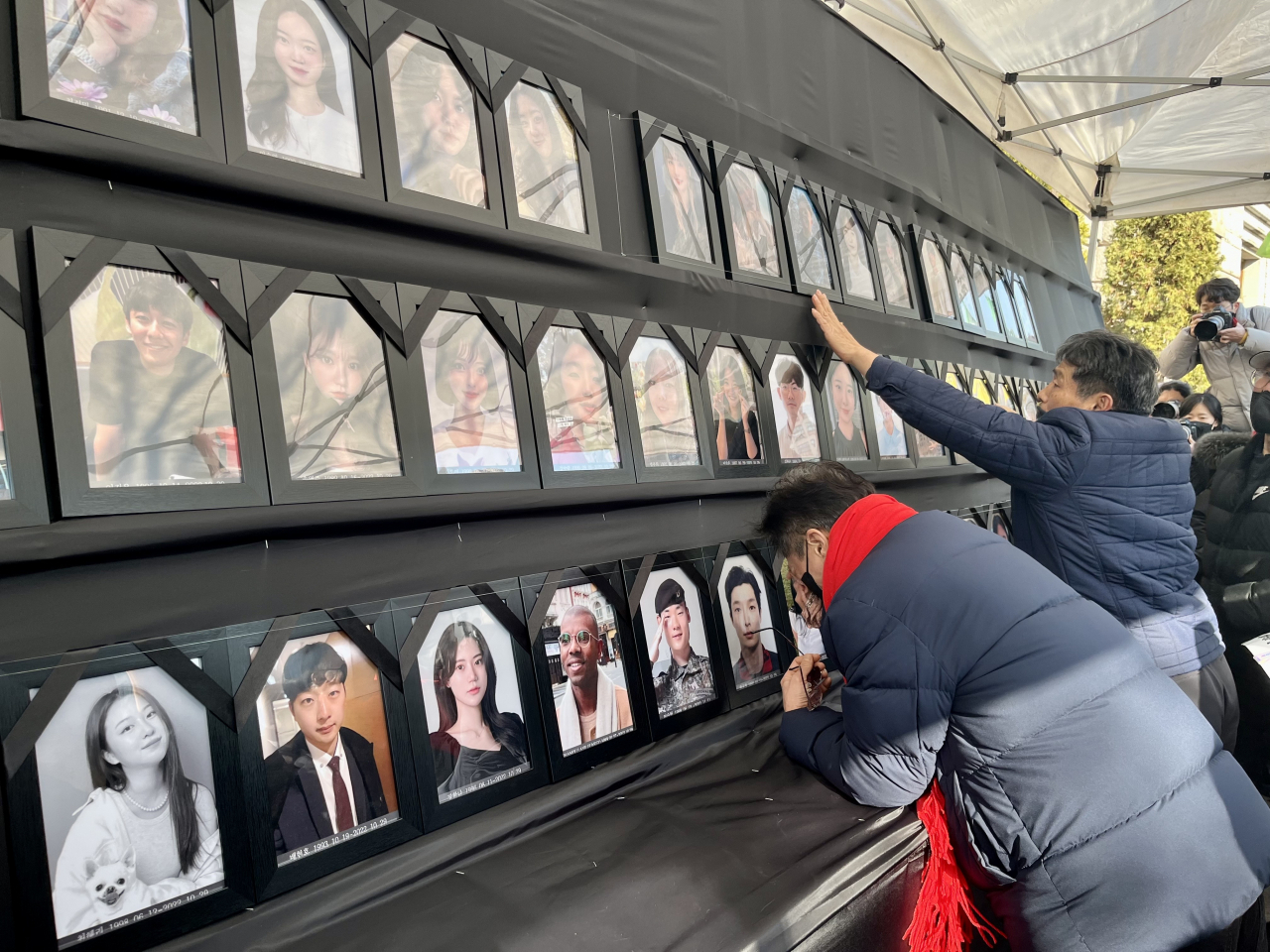 A father cries before the portrait of his late son on the memorial altar set up outside Seoul City Hall on Saturday. (Kim Arin/The Korea Herald)
