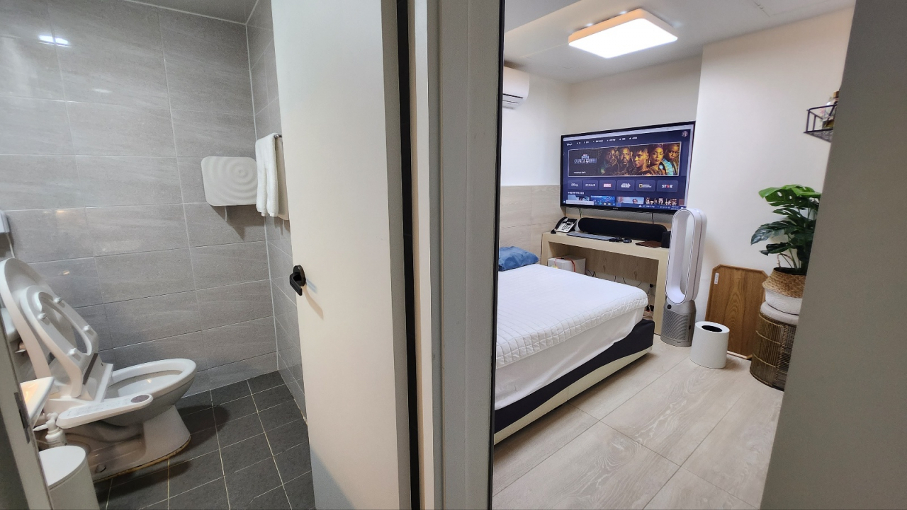 The room inside the room cafe in Sinchon is equipped with a separate bathroom, bed, air purifier, air conditioner and television. (Lee Jung-youn/The Korea Herald)