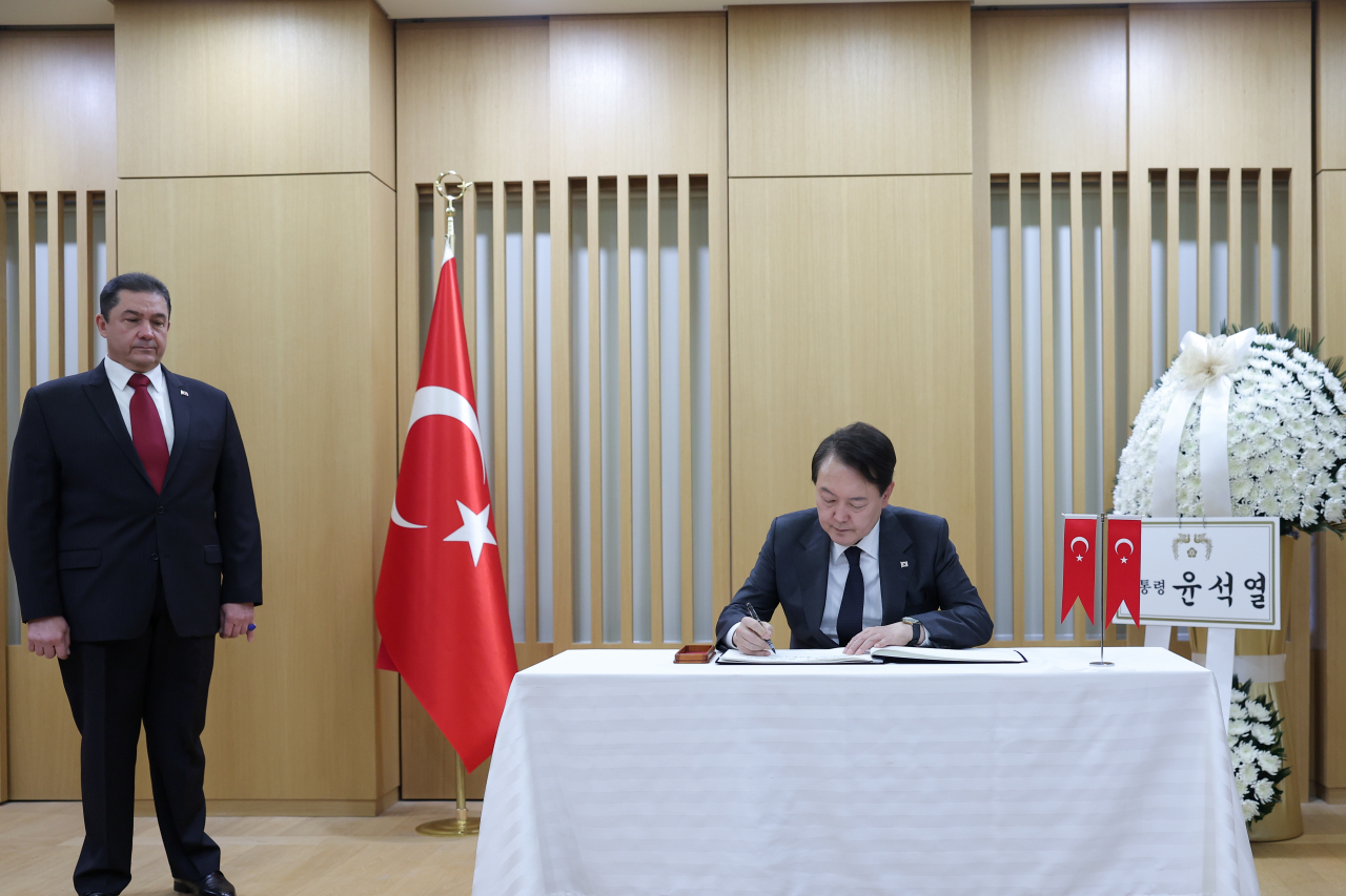 President Yoon Suk Yeol signs a condolence book at the Turkish Embassy in Seoul on Thursday. (Yonhap)