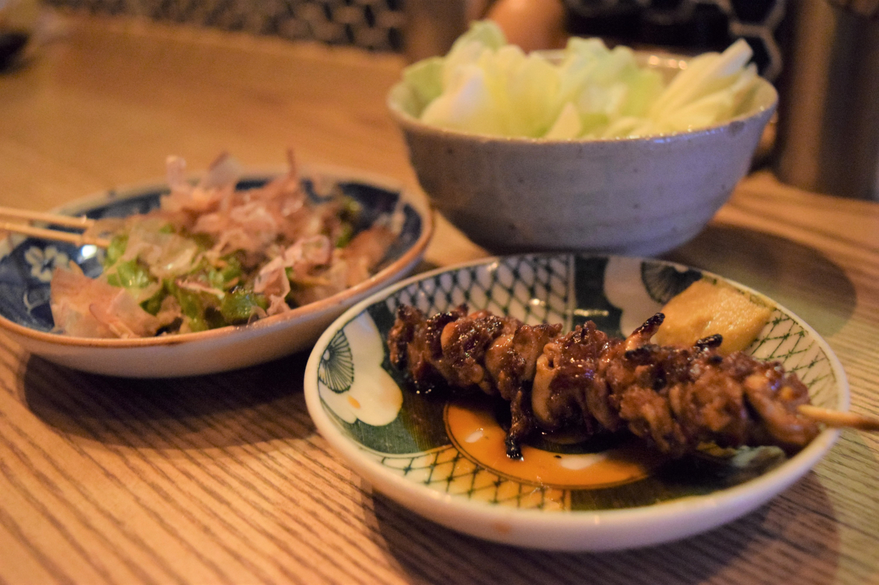 Dak daedongmaek (chicken main artery) kkochi, a specialty menu at Yakitori Yoisa, alongside chili pepper kkochi with katsuobushi sprinkled on top (Kim Hae-yeon/ The Korea Herald)