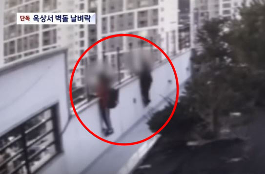JTBC screen capture from security camera footage showing kids throwing bricks.