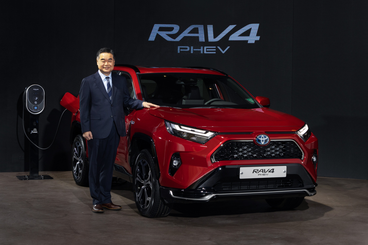 Konyama Manabu, CEO of Toyota Motor Korea, poses for photos with the automaker's newly launched RAV4 plug-in hybrid electric vehicle during a press conference at Toyota Korea's multicultural complex in Seoul on Tuesday. (Toyota Motor Korea)