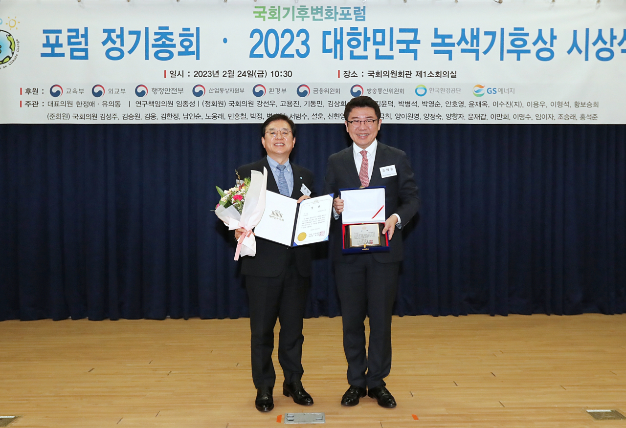 Park Jong-il (left), vice president of Woori Financial Group, and People Power Party Rep. Yu Eui-dong, a member of the National Assembly Forum on Climate Change, pose for a photo during the 2023 Korea Green and Climate Award held in Seoul on Friday. (Woori Financial Group)