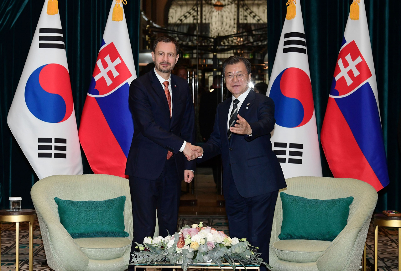 Former South Korean President Moon Jae-in (R) and Slovak Prime Minister Eduard Heger shake hands before S. Korea-Slovakia summit talks at a hotel in Budapest, Hungary, in November 2021.(Embassy of Slovakia in Seoul)