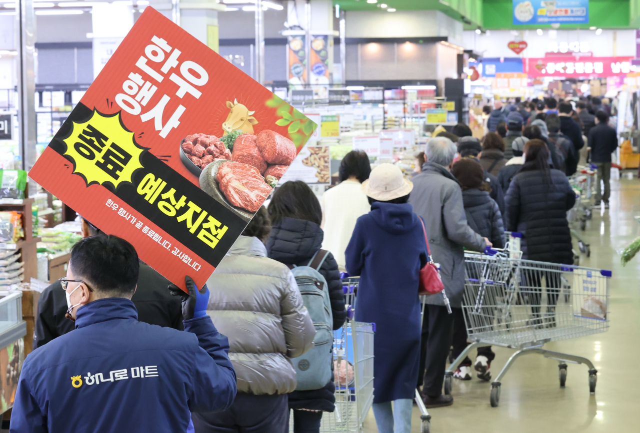 Shoppers wait in a line to purchase dicount products at a supermarket in southern Seoul last Tuesday. (Yonhap)