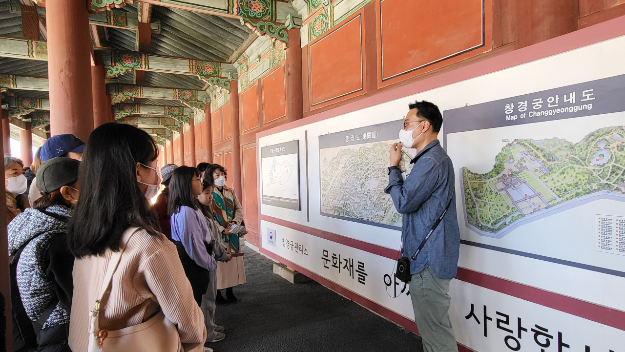 A cultural heritage commentator explains the buildings depicted in Donggwoldo at Changgyeonggung, Sunday. (Kim Hae-yeon/ The Korea Herald)