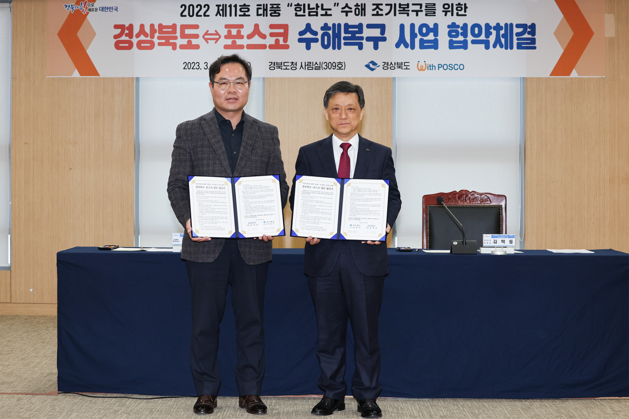 Posco Vice Chairman Kim Hak-dong (right) and Kim Hak-hong, deputy governor of North Gyeongsang Province, pose for a picture after a signing ceremony at the provincial government office in Andong, on Monday. (Posco)