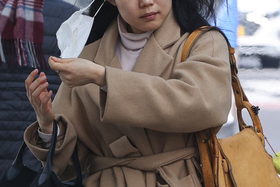 A woman takes off her mask at a bus station in Gwanghwamun, central Seoul, on Sunday. (Yonhap)
