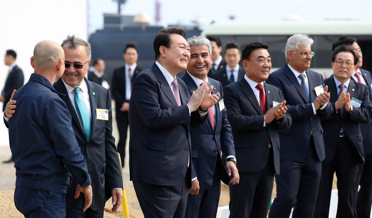 President Yoon Suk Yeol (third from left) talks with Hussain A. Al-Qahtani (fourth from left), chief of S-Oil Corp, a South Korea-based refiner owned by Saudi Arabia's state oil giant Aramco, during a groundbreaking ceremony at Onsan industrial park in Ulsan on Thursday. (Yonhap)