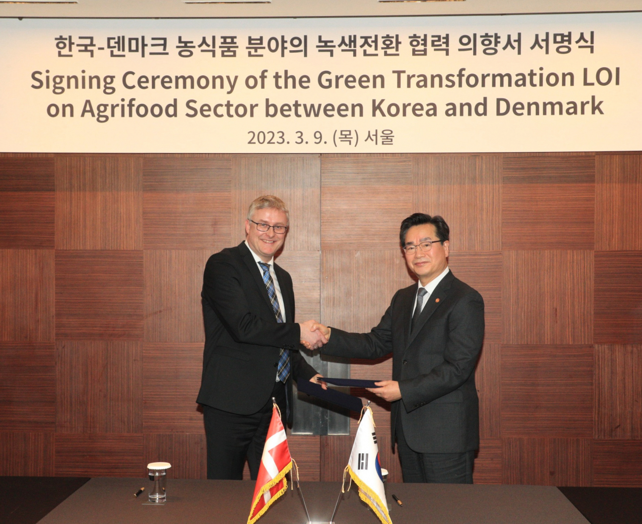 South Korean Minister for Agriculture, Food and Rural Affairs Chung Hwang-keun (right) and his Danish counterpart, Jacob Jensen, pose for a photo after signing a letter of intent to cooperate on promoting the green transformation of the agrifood sector at the Shilla Seoul in Jung-gu, Seoul on Thursday. (Ministry of Agriculture, Food and Rural Affairs)