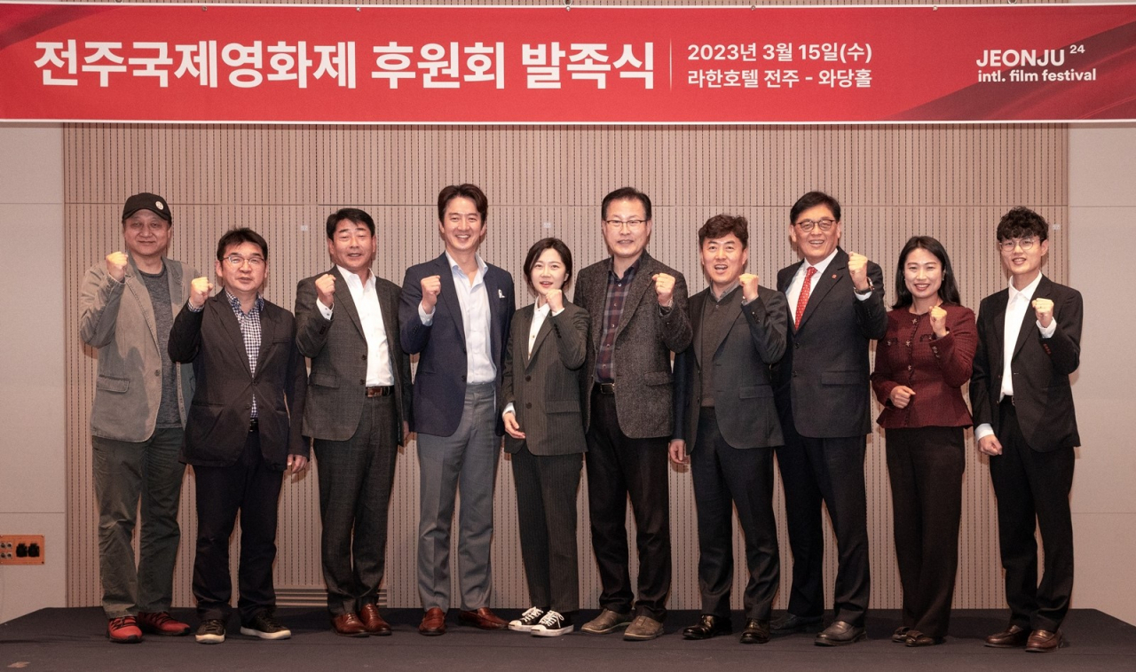 Min Seong-wook (far left) and Jung Jun-ho (fourth from left), co-chairs of the JIFF executive committee, pose with donation committee members in Jeonju, North Jeolla Province, Wednesday. (JIFF)