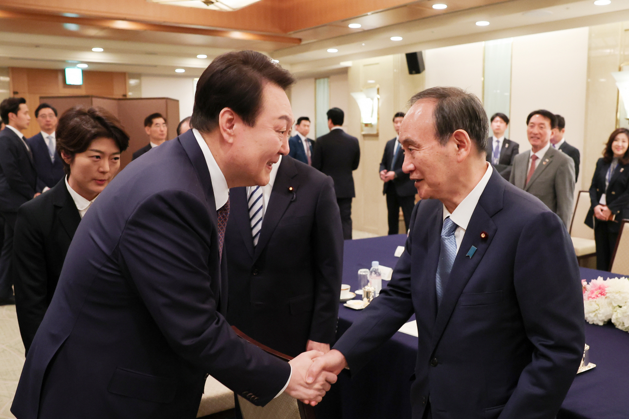 President Yoon Suk Yeol meets with former Japanese Prime Minister Yoshihide Suga, who will serve as the next president of the Japan-Korea Parliamentarians Federation, in a hotel in Tokyo on Friday. (Yonhap)