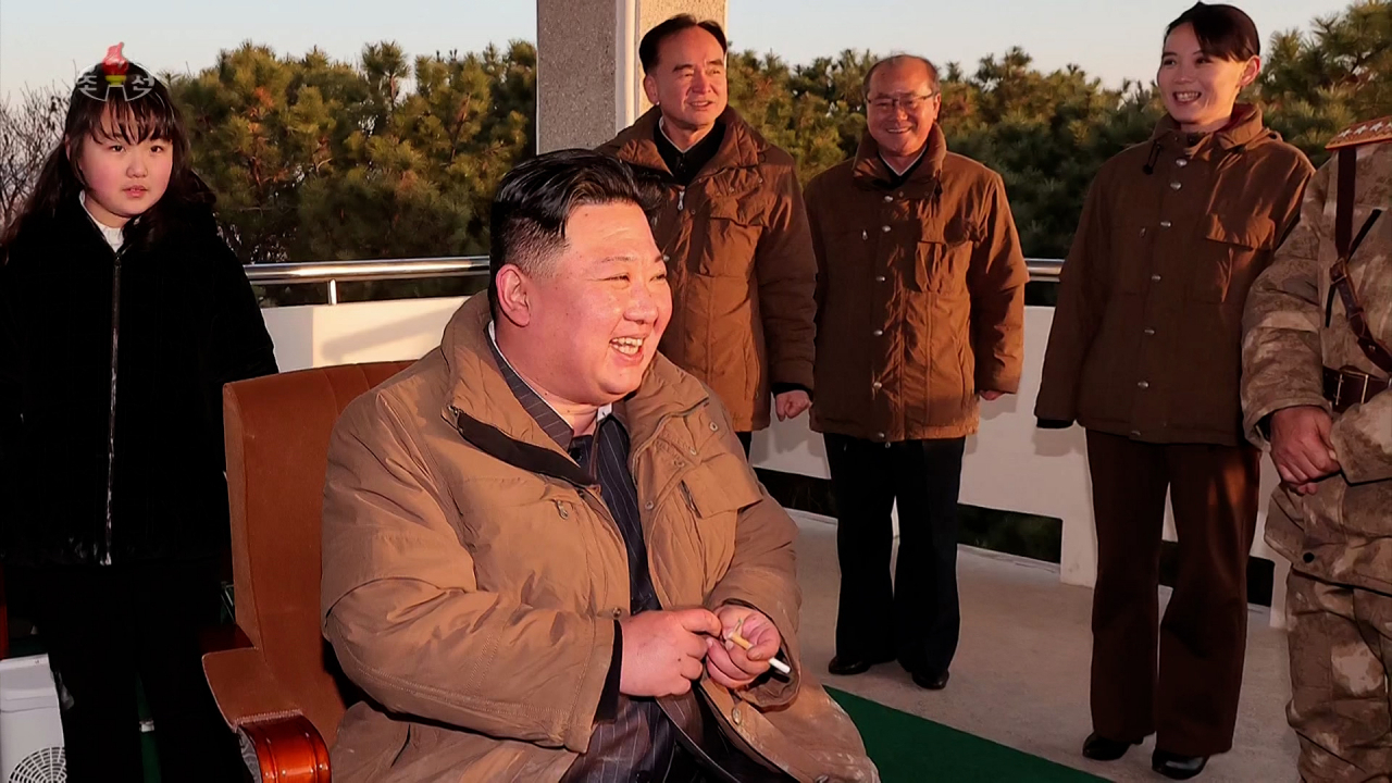North Korean leader Kim Jong-il (second from left) and his daughter Ju-ae (left) watch the launch of the Hwasong-17 intercontinental ballistic missile on March 16, in this video revealed March 17. (KCNA)