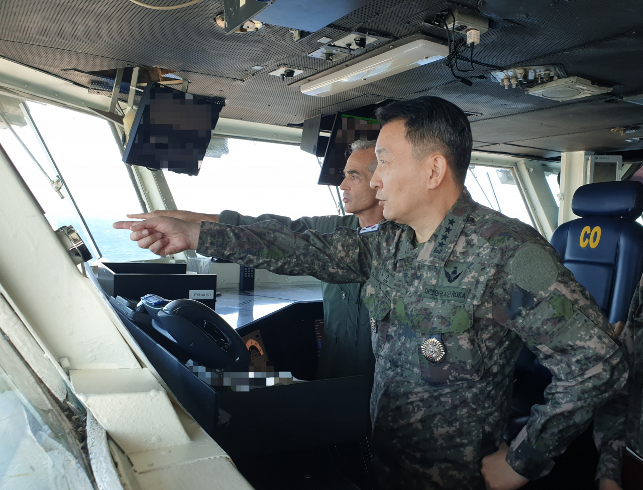 South Korea's Joint Chiefs of Staff Chairman Gen. Kim Seung-kyum (right) and UN Navy Capt. Craig Sicola, who serves as the commanding officer of the USS Nimitz, are on board the US aircraft carrier during combined maritime exercises between the South Korean and US navies staged in international waters south of Jeju Island on Monday. (Joint Chiefs of Staff)