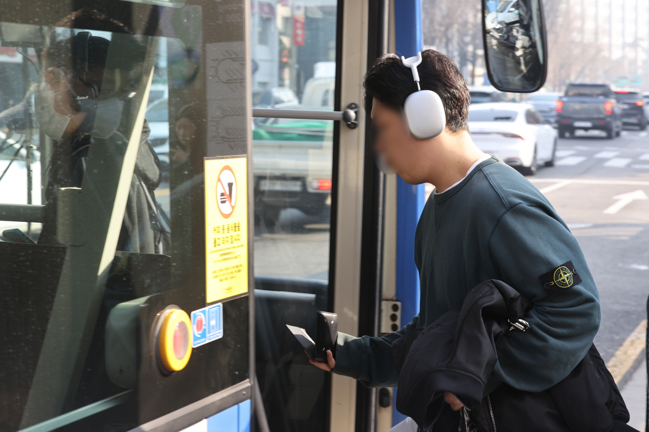 This file photo shows a person without a mask getting on a bus in Seoul last Monday as the government lifted the mask mandate on public transportation.
