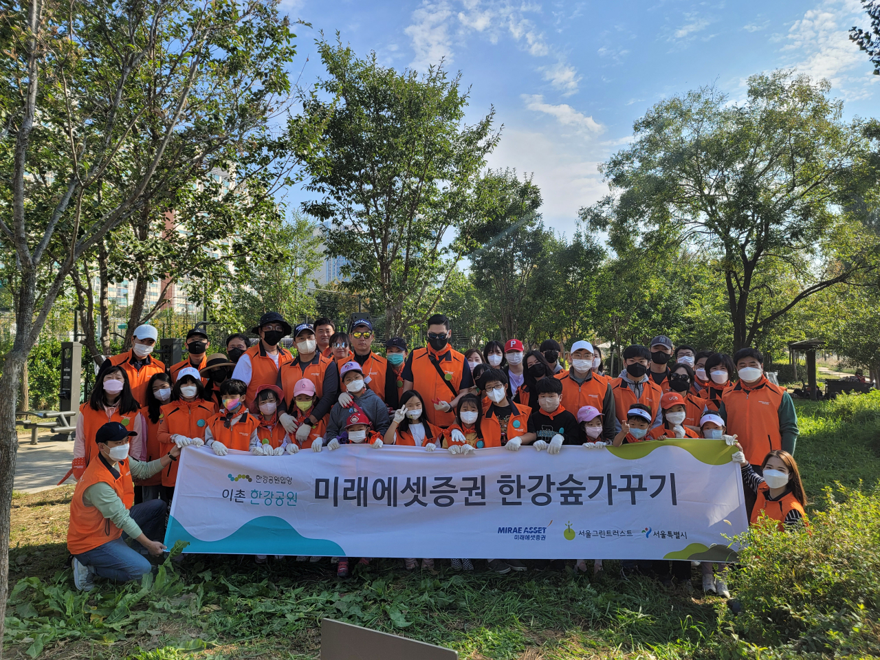 Mirae Asset Securities employees and their family members pose for a photo after a planting event held along the Han River in Seoul. (Mirae Asset Securities)
