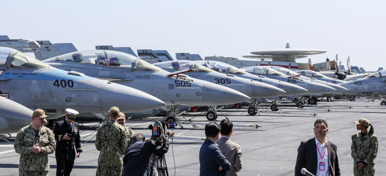 Dozens of fighter jets, including F/A-18 Super Hornet tactical aircraft and EA-18G Growler electronic attack aircraft, are on standby on the deck of the US nuclear-powered aircraft carrier USS Nimitz, which makes a call at a naval base in the port city of Busan, 325 kilometers southeast of Seoul, on March 28, 2023. (Pool photo) (Yonhap)