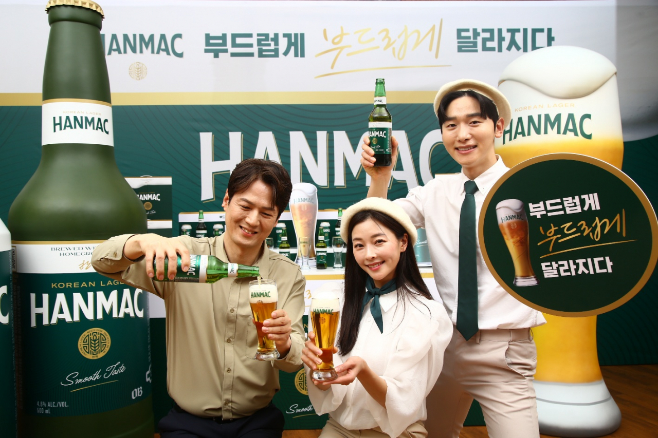 Models pose with the new Hanmac, the upgraded version of Oriental Brewery's Korean rice-based lager, at a promotional event held in Seoul on Monday. (Oriental Brewery)