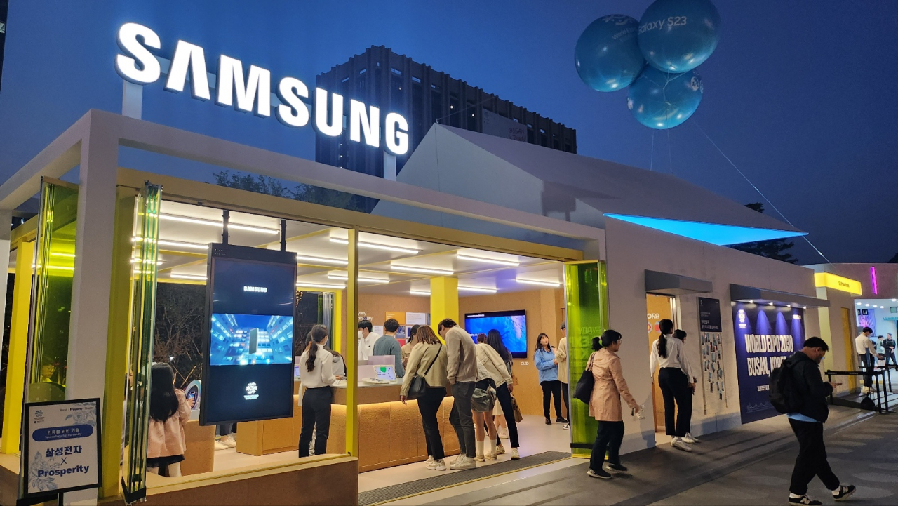 Passersby look through Samsung Electronics' exhibition in Samsung Electronics's booth in Gwanghwamun Plaza, central Seoul, Sunday. (Lee Jung-youn/The Korea Herald)