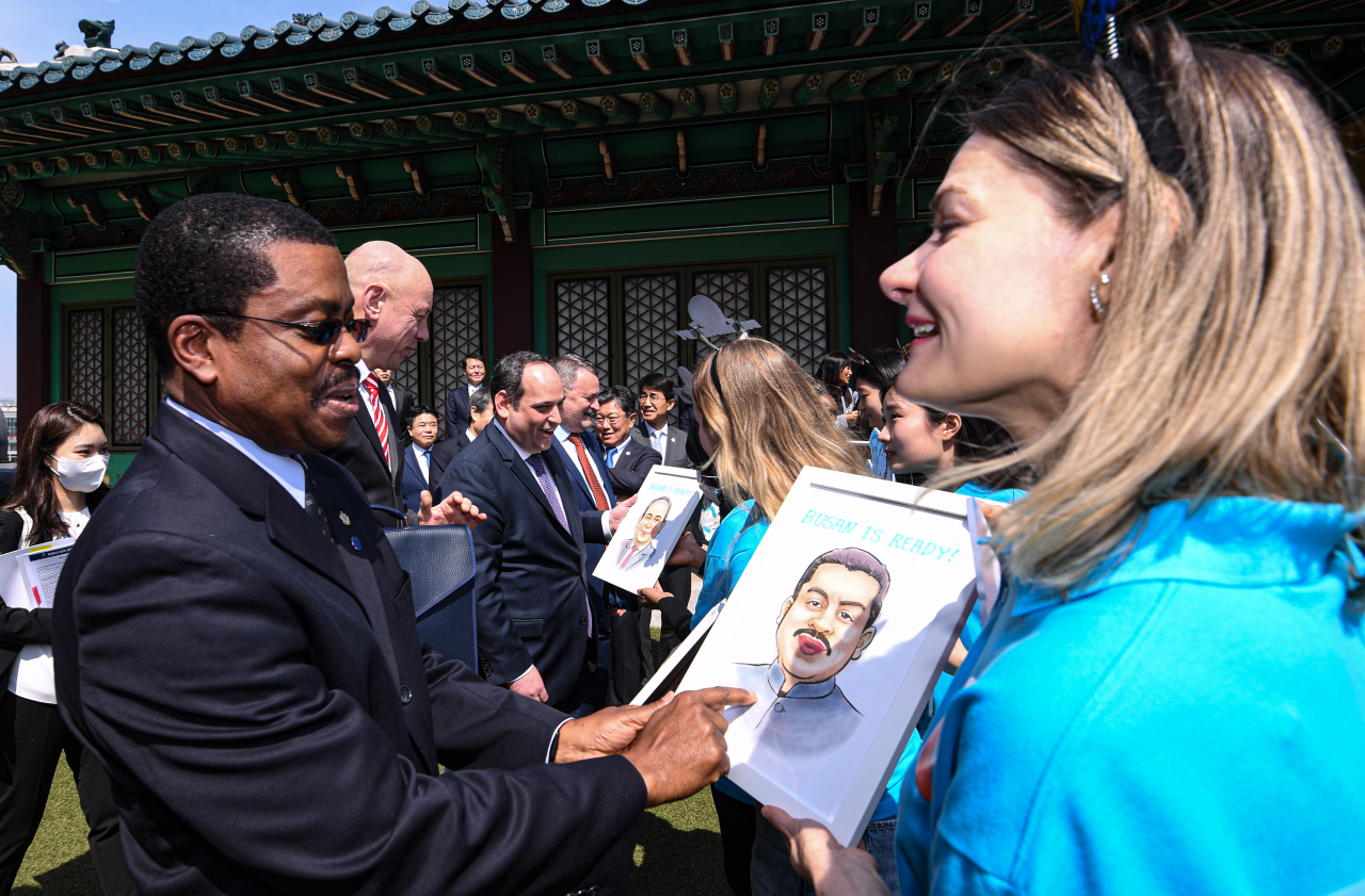 Members of the Bureau International des Expositions (BIE) Enquiry Mission receive caricature drawings of themselves from the official supporters' club of the 2030 Busan World Expo in Seoul on Monday. (Joint Press Corp.)