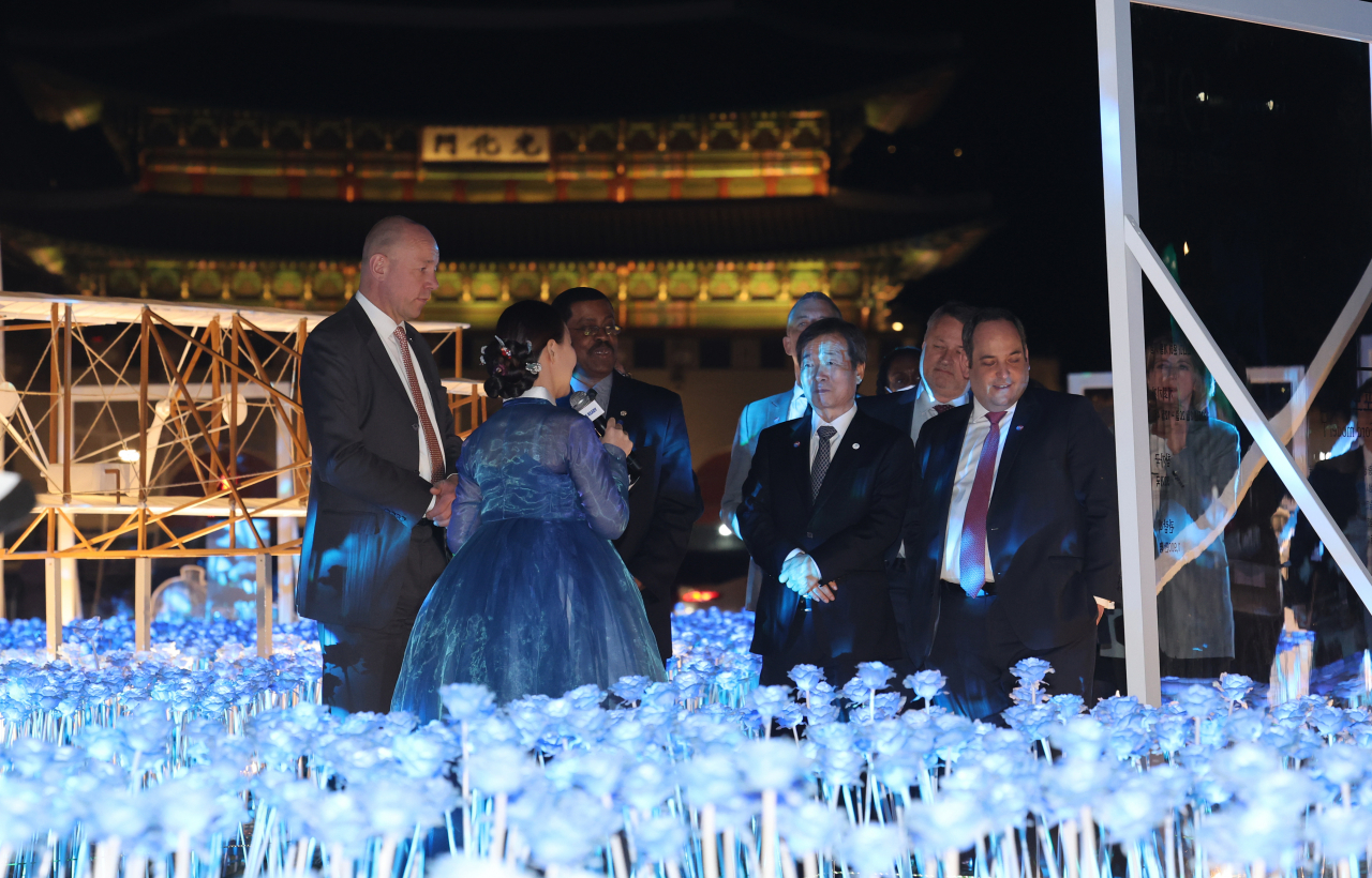 The BIE delegation visits Gwanghwamun Plaza in Seoul on Monday night, listening to the guide's explanation and viewing promotional materials. (Yonhap)