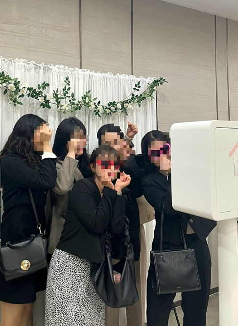 Wedding guests pose for a picture in front of an instant photo machine. (Courtesy of Banzzak)