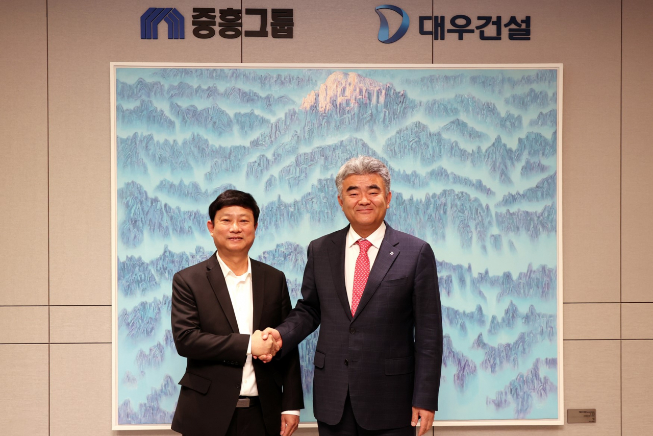 Jungheung Group Vice Chairman Jung Won-ju (right) and Vietnam's Binh Duong Provincial People's Committee Chairman Vo Van Minh pose for a photo after Chairman Vo’s visit to the Daewoo E&C headquarters on Thursday. (Daewoo Engineering & Construction)