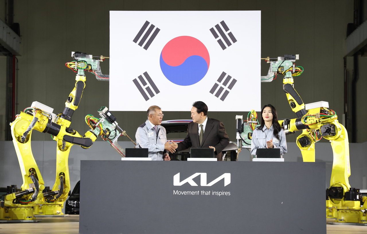 President Yoon Suk Yeol (center) and Hyundai Motor Group Executive Chair Chung Euisun shake hands during the ground-breaking ceremony of the carmaker’s first electric vehicle-only manufacturing plant in Hwaseong, Gyeonggi Province, on Tuesday. (Joint Press Corp)